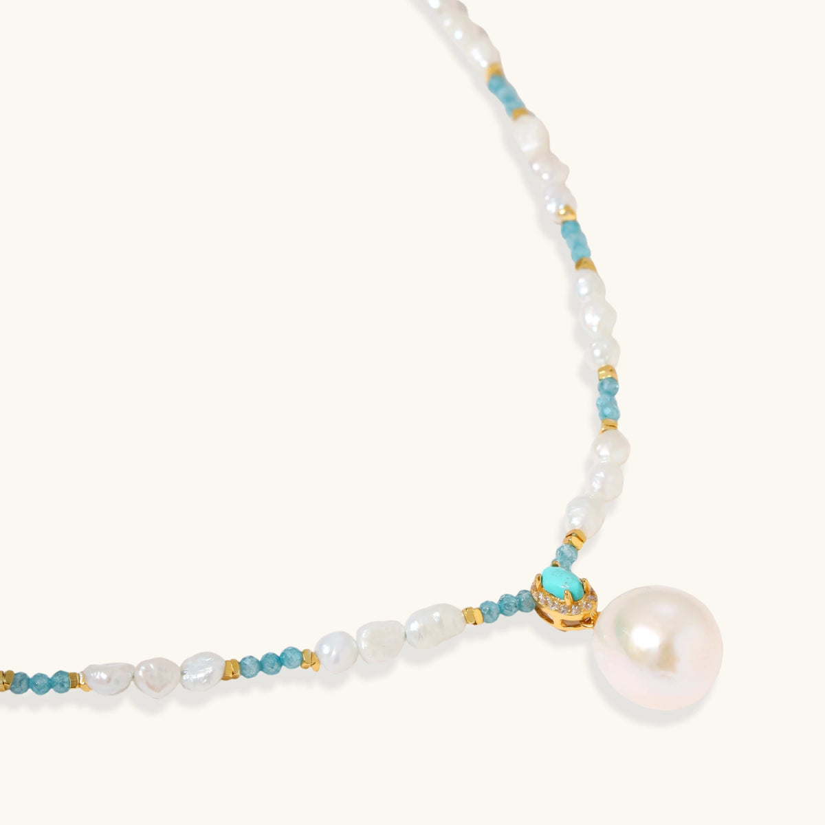 Beaded necklace with baroque pearls, turquoise stones, and gold accents featuring a large pearl pendant on white background.